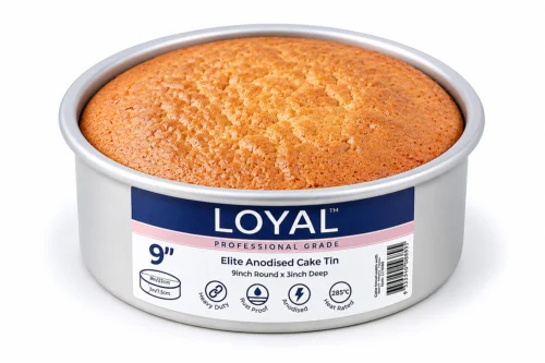 Round cake tin with freshly baked sponge cake in heavy-duty anodised aluminium cake pan